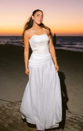 Strapless ivory satin gown worn on a beach at sunset